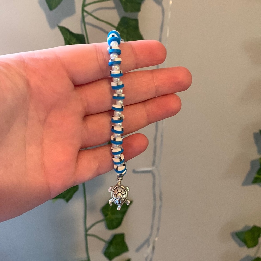 Blue with black and white and a pearl charm between,clay bead bracelet